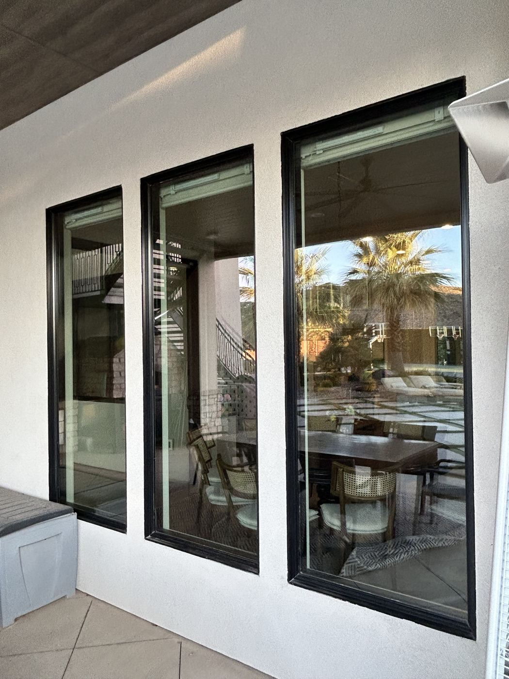 Spotless patio windows reflecting palm trees